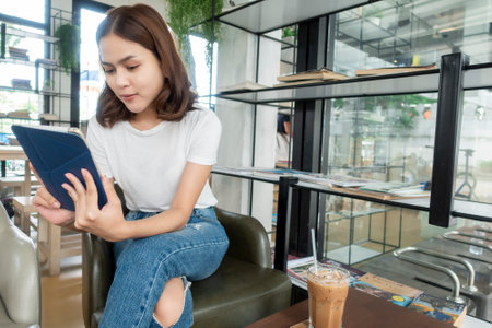 Beautiful business girl working with tablet , smartphone and drinking coffee in coffee shopの写真素材