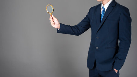 close up of business man is research data on gray backgroundの写真素材