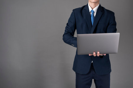 Business man is using laptop ,grey background in studioの写真素材
