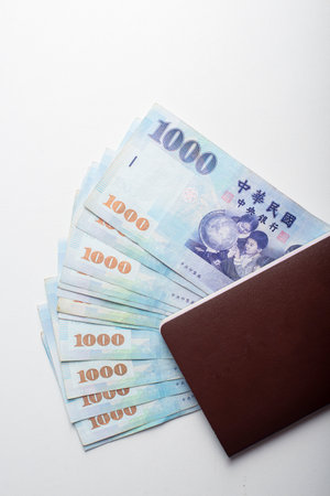Passport and 1000 New Taiwan Dollar bill on white backgroundの写真素材