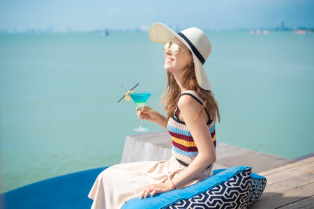 Beautiful woman is drinking ice summer drink in the beach, summer conceptの写真素材
