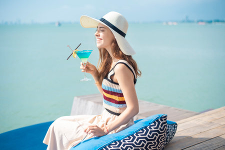 Beautiful woman is drinking ice summer drink in the beach, summer conceptの写真素材