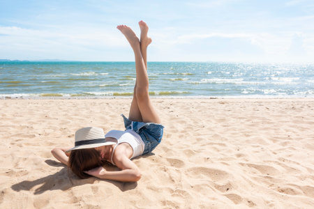 A woman is laying on the Beachの写真素材