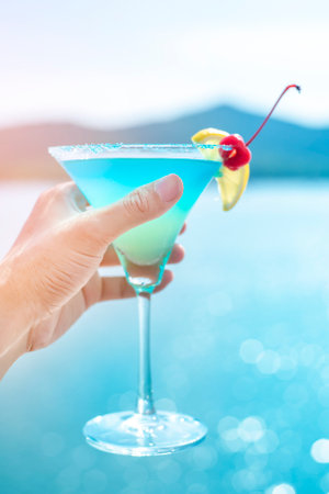 Human hand is holding  summer drink on beachの写真素材