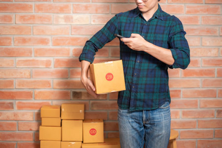 A man entrepreneur owner SME business is packaging box to send his customerの写真素材