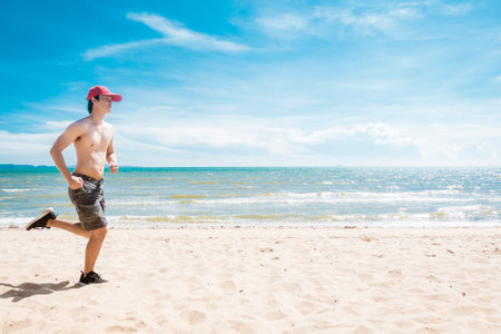 Muscular man is running on the beachの写真素材