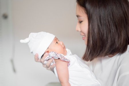 Beautiful woman holding a newborn baby in her arms