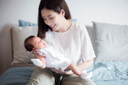 Beautiful woman holding a newborn baby in her arms