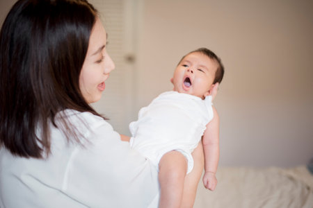 Beautiful woman holding a newborn baby in her armsの写真素材