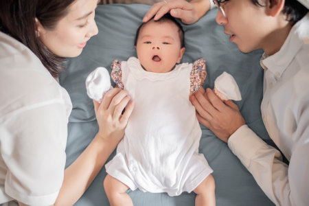 happy family, mom and dad are playing with they cute  newborn babyの写真素材