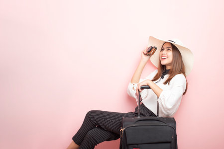 Beautiful traveler woman is exciting in pink backgroundの写真素材