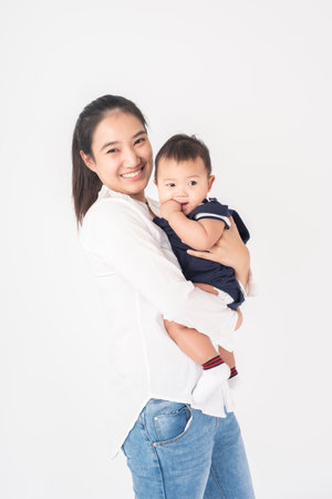 Happy newborn cute baby and beautiful mom in studioの写真素材