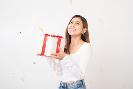 Beautiful happy woman is celebrating in studio white backgroundの写真素材