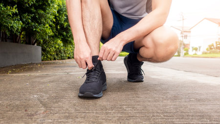 Close up of fitness man is tie shoes