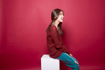 Beautiful woman portrait in studio on red backgroundの写真素材