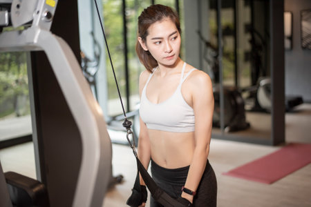 Beautiful asian woman is doing exercise in the gymの写真素材
