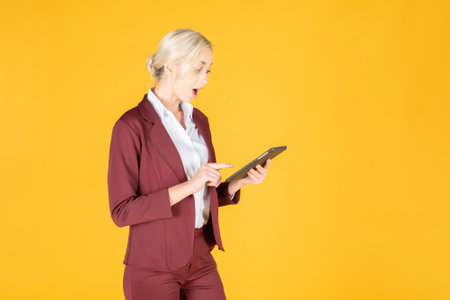 Business woman is surprising  in studio yellow backgroundの写真素材