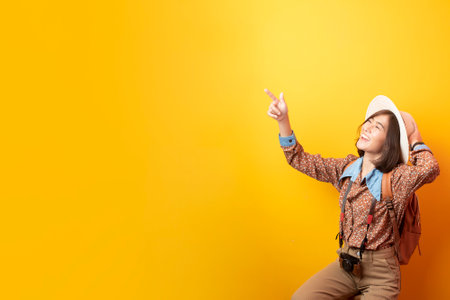 Happy Young Asian tourist woman on yellow backgroundの写真素材