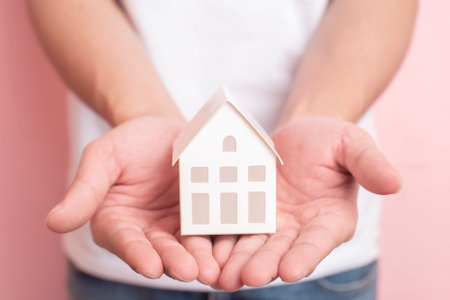 Small white house on human handの写真素材