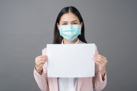 Business woman with  surgical mask is holding blank paperの写真素材