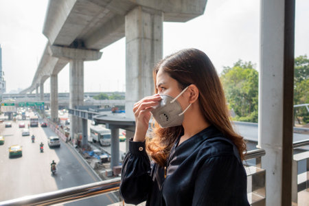 Beautiful woman wearing anti dust mask protect air pollution and pm 2.5 on street cityの写真素材