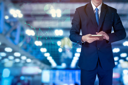 Close up of business man is using tablet  with analytics finance graphicの写真素材