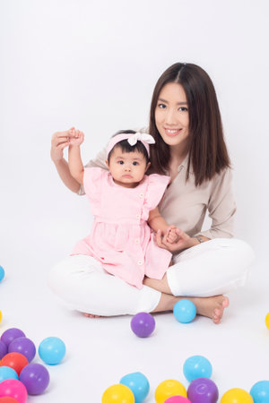 Asian mother and adorable baby girl are  happy on white backgroundの写真素材