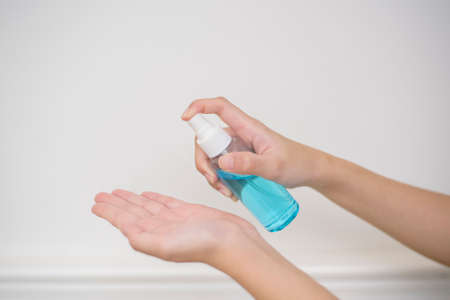woman is cleaning her hands with alcohol spray