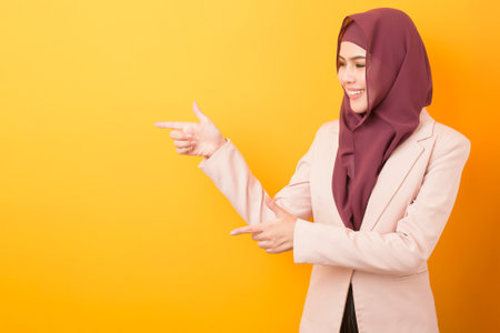 Beautiful business woman with hijab portrait on yellow backgroundの写真素材