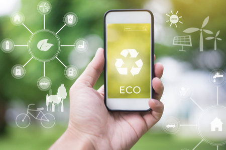 Close up man hand using smartphone on green with ecological icons, save earth conceptの写真素材