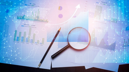 Magnifying glass and documents with analytics data lying on tableの写真素材