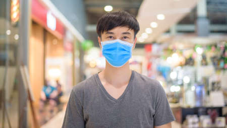 Asian man is wearing surgical mask in shopping mallの写真素材