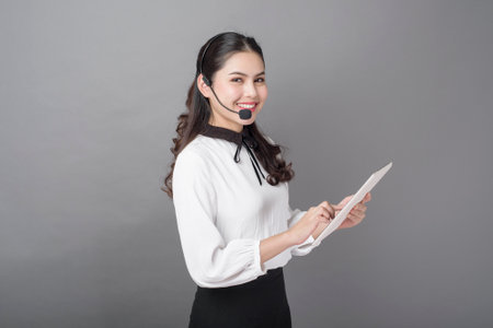 Portrait of beautiful operator woman on gray backgroundの写真素材