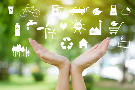 Human hand is holding ecological icons on green, save earth concept.
