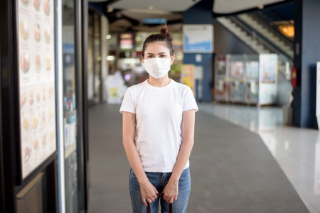 young woman with mask standing outdoorの写真素材