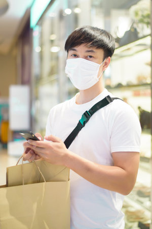 Portrait of man is wearing face mask in shopping centerの写真素材