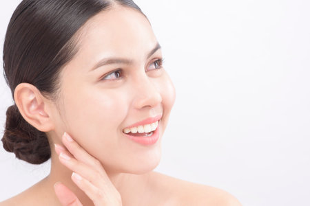 Close up beauty portrait of a young smiling woman isolated over white background studioの写真素材