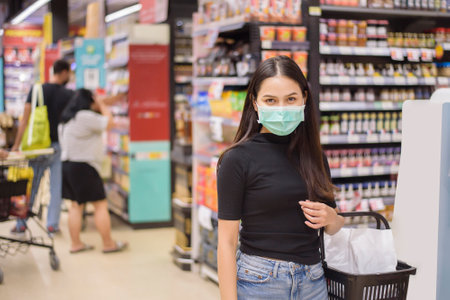 woman with face mask is shopping clothes in Shopping centerの写真素材