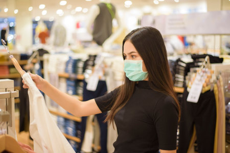 woman with face mask is shopping clothes in Shopping centerの写真素材