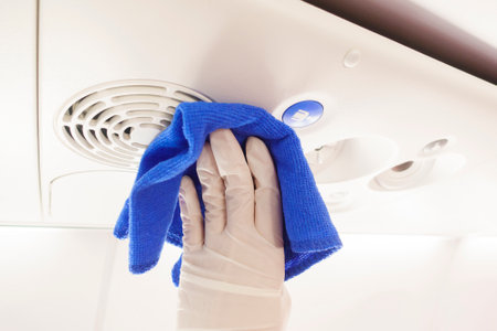 Close up hand is wearing gloves cleaning aircraft for covid-19 prevention pandemicの写真素材