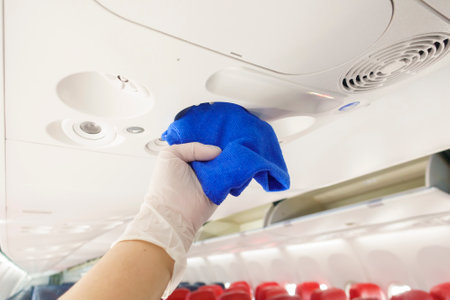 Close up hand is wearing gloves cleaning aircraft for covid-19 prevention pandemicの写真素材