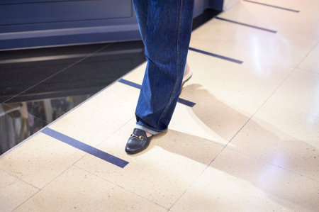 Close up woman legs is standing on social distancing line in shopping mall , New normal , social...