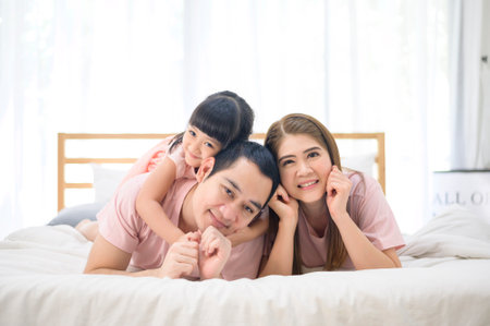 portrait of happy Asian family in white bedroomの写真素材