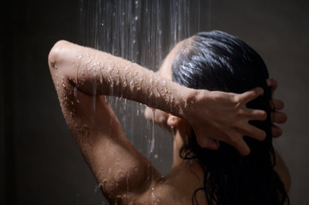 Young beautiful woman taking shower in a bathroom at homeの写真素材