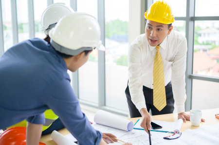 Engineering people are analytics construction plans with blueprint in office .の写真素材