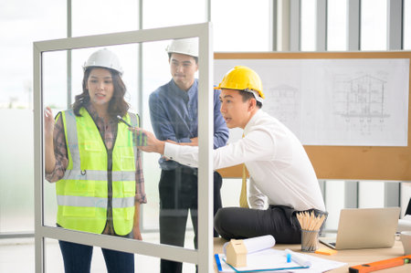 Engineering people are analytics construction plans with blueprint in office .