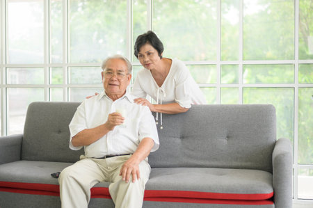 Happy elderly couple drinking milk and spending time together at home, health and retirement concept
