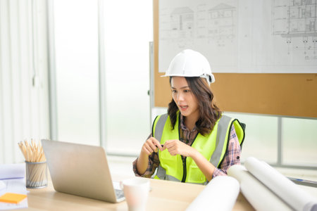 A female engineer using laptop, making video call to client or business partner