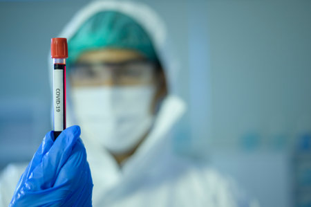 A scientist holding liquid chemical tube in laboratory, Science and technology healthcare concept