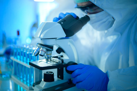 A scientist using microscope during experiment in laboratory, Science and technology healthcare conceptの写真素材